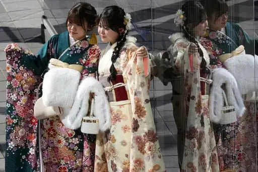 Kimono-clad women take a photo after a ceremony to celebrate the Coming-of-Age Day, a centuries-old tradition and national holiday celebrating the milestone from child to adult, in Yokohama near Tokyo, Monday, Jan. 13, 2025. (AP Photo/Eugene Hoshiko)