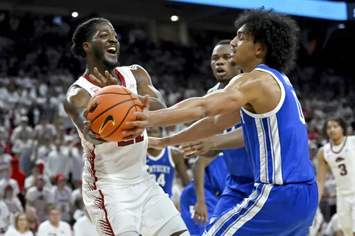 Arkansas forward Makhel Mitchell (22) tries to pass the ball past Kentucky forward Jacob Toppin (0) during the second half of an NCAA college basketball game Saturday, March 4, 2023, in Fayetteville, Ark. (AP Photo/Michael Woods)