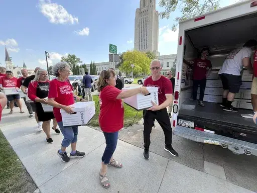 Organizers load boxes of signed petitions seeking to get a measure on the November ballot that would repeal a new Nebraska law providing taxpayer money for private school tuition, Wednesday, July 17, 2024, in Lincoln, Neb. Support Our Schools organizers say they turned in more than 86,000 signatures to the Nebraska Secretary of State's office. (AP Photo/Margery Beck)