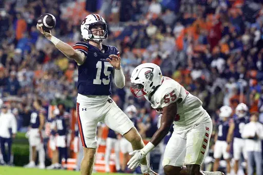 Auburn quarterback Hank Brown (15) looks to throw a pass for a touchdown as New Mexico edge Antoineo Harris Jr. (55) pressures him during the second half of an NCAA college football game, Saturday, Sept. 14, 2024, in Auburn, Ala. (AP Photo/Butch Dill)