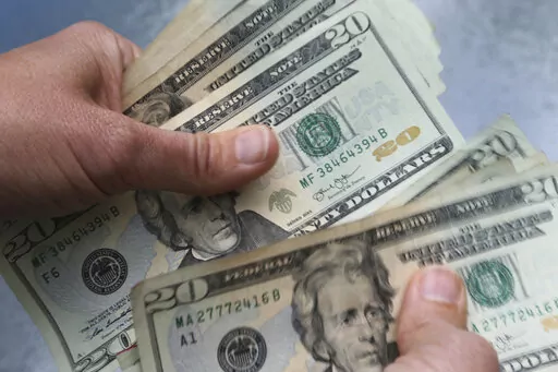 In this June 15, 2018 file photo, twenty dollar bills are counted in North Andover, Mass. Whether your New Year’s resolutions were to save more, spend less or pay off debt, life might already be getting in the way. Unpredictable expenses early in the year can complicate your goals, but they don’t have to knock you completely off course. (AP Photo/Elise Amendola, File)