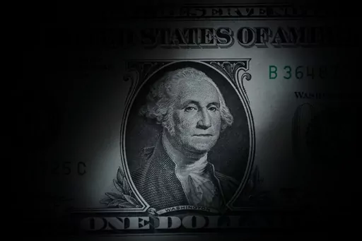 The likeness of George Washington is seen on a U.S. one dollar bill, Monday, March 13, 2023, in Marple Township, Pa. If you’ve sat your kids down to discuss Roth IRAs and compound interest, you might have been going about things the wrong way. Investing can seem dry and unapproachable, especially for kids, but the concept is amazing. (AP Photo/Matt Slocum, File)