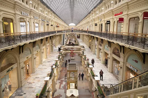 Few visitors walk inside the GUM department store in Moscow, in Moscow, Russia, Friday, March 4, 2022. Three months after the Feb. 24 invasion, many ordinary Russians are reeling from those blows to their livelihoods and emotions. Moscow's vast shopping malls have turned into eerie expanses of shuttered storefronts once occupied by Western retailers. (AP Photo, File)