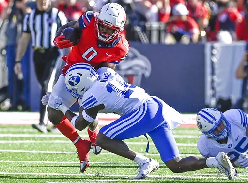 Liberty running back Dae Dae Hunter, left, protects the ball from BYU's Kaleb Hayes during an NCAA college football game, Saturday, Oct. 22, 2022, in Lynchburg, Va. (Paige Dingler/The News & Advance via AP)