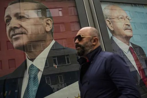 A man walks past election campaign billboards of Turkish President and People's Alliance's presidential candidate Recep Tayyip Erdogan, left, and CHP party leader and Nation Alliance's presidential candidate Kemal Kilicdaroglu in Istanbul, Turkey, Friday, May 5, 2023. (AP Photo/Emrah Gurel)