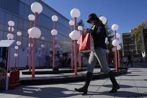 A shopper walks through a mall district in Beijing, Saturday, Nov. 11, 2023. Shoppers in China have been tightening their purse strings, raising questions over how faltering consumer confidence may affect the annual Singles' Day online retail extravaganza. (AP Photo/Ng Han Guan)