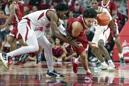 Alabama guard Mark Sears, front right, drives past Arkansas forward Karter Knox, left, during the first half of an NCAA college basketball game Saturday, Feb. 8, 2025, in Fayetteville, Ark. (AP Photo/Michael Woods)