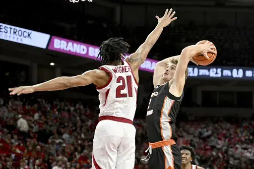 Pacific forward Elias Ralph (2) drives past Arkansas guard D.J. Wagner (21) to score during the first half of an NCAA college basketball game Monday, Nov. 18, 2024, in Fayetteville, Ark. (AP Photo/Michael Woods)