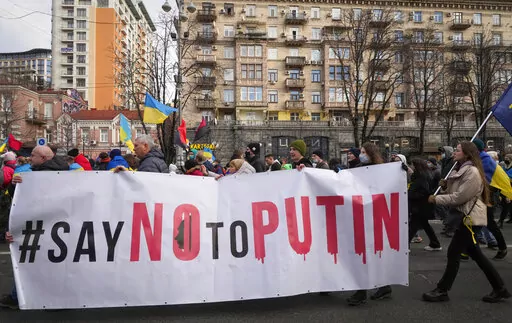 Ukrainians attend a rally in central Kyiv, Ukraine, Saturday, Feb. 12, 2022, during a protest against the potential escalation of the tension between Russia and Ukraine. Russian President Vladimir Putin and U.S. President Joe Biden are to hold a high-stakes telephone call on Saturday as tensions over a possibility imminent invasion of Ukraine escalated sharply and the U.S. announced plans to evacuate its embassy in the Ukrainian capital. (AP Photo/Efrem Lukatsky)
