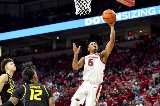Arkansas guard Au'Diese Toney (5) drives past Missouri defenders Trevon Brazile (23) and DaJuan Gordon (12) to score during the first half of an NCAA college basketball game Wednesday, Jan. 12, 2022, in Fayetteville, Ark. (AP Photo/Michael Woods)