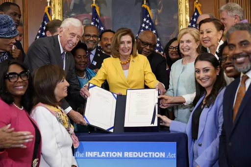 House Speaker Nancy Pelosi of Calif., and the House Democrats with her, celebrate after Pelosi signed the Inflation Reduction Act of 2022 during a bill enrollment ceremony on Capitol Hill in Washington, Aug. 12, 2022. It's a once-in-a-generation undertaking, thanks to three big bills approved by Congress last session. They're now coming online. President Joe Biden calls it "Bidenomics." Republicans criticize it as big government overreach. Taken together, the estimated $2 trillion is a centerpie