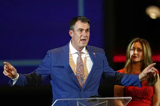 Oklahoma Gov. Kevin State, left, addresses a campaign rally with his wife, Sarah Stitt, right, Tuesday, Nov. 1, 2022, in Oklahoma City. (AP Photo/Sue Ogrocki)