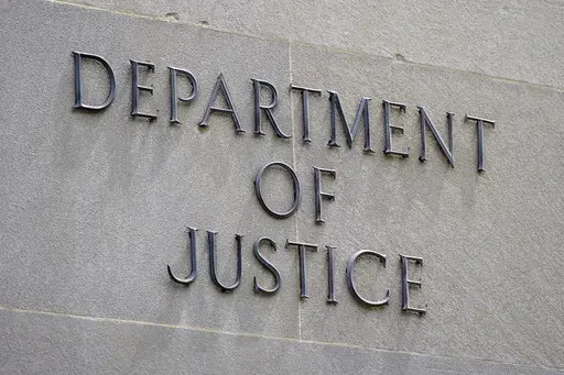 This May 4, 2021 file photo shows a sign outside the Robert F. Kennedy Department of Justice building in Washington. A Russian internet propaganda campaign backed by the Kremlin that spread disinformation in the United States and relied on artificial intelligence has been disrupted. That's according to the U.S. Justice Department, which announced Tuesday that it seized nearly 1,000 bogus social media accounts. (AP Photo/Patrick Semansky)