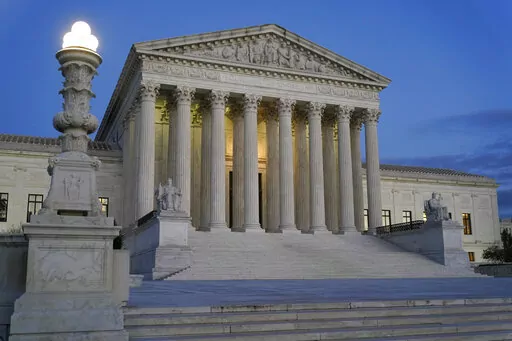 Light illuminates part of the Supreme Court building at dusk on Capitol Hill in Washington, Nov. 16, 2022. The court is set to hear arguments Wednesday in a case from North Carolina, where Republican efforts to draw congressional districts heavily in their favor were blocked by a Democratic majority on the state Supreme Court because the GOP map violated the state constitution. (AP Photo/Patrick Semansky, File)