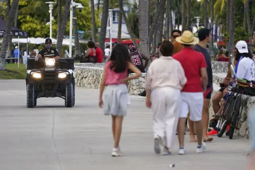 A police officer on an ATV patrols in Miami Beach, Florida's famed South Beach, Monday, March 22, 2021. City of Miami Beach officials declared a state of emergency on Monday, March 21, 2022, and an upcoming curfew, bidding to curb violent incidents at spring break that saw five people wounded in two separate shootings. (AP Photo/Wilfredo Lee, File)