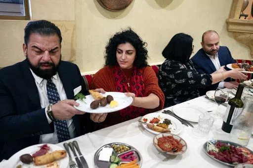 Sophia Armen, center passes a dish to Dr. Armond Aghakhanian and joined for lunch with other members of the Armenian-American Census Coalition, Suzie Abajian and former California Assembly Member Adrian Nazarian at the Carousel, a Lebanese-Armenian restaurant in Glendale, Calif. on Friday, May 17, 2024. For some race and ethnic groups, how the U.S. government categorizes them for crucial surveys and the once-a-decade census is still falling short. Hmong as well as Armenian, Arab American and Bra