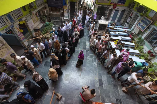 People queue up to cast their vote in the sixth round of polling in India's national election in New Delhi, India, Saturday, May 25, 2024. (AP Photo/Altaf Qadri)