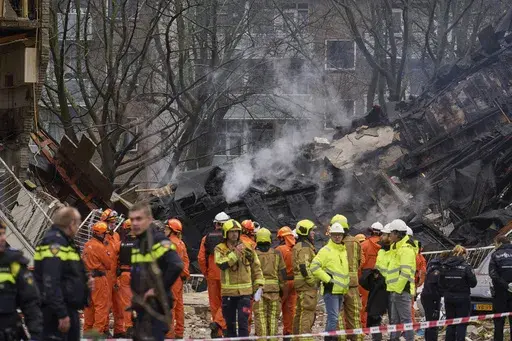 Firefighters stand by a building destruction at the site of an explosion which destroyed several apartments and injured multiple people, at The Hague, Saturday, Dec. 7, 2024. (AP Photo/Phil Nijhuis)
