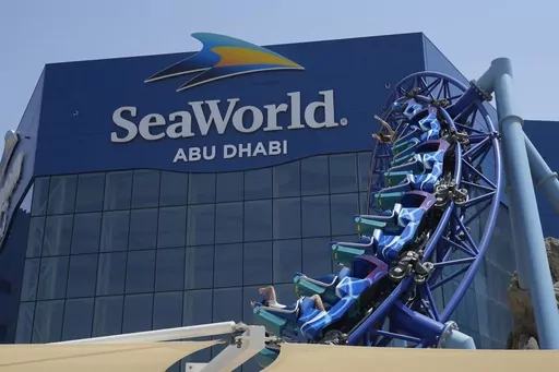 People enjoy riding on a roller coaster at the SeaWorld on Yas Island in Abu Dhabi, United Arab Emirates, on May 26, 2023. It’s the first venture outside the United States for the theme park chain, which had been mired in controversy in recent years over the treatment of captive killer whales. The $1.2 billion Abu Dhabi venture with state-owned developer Miral features the world's largest aquarium and cylindrical LED screen, as well as state-of-the-art facilities housing dolphins, seals, and o