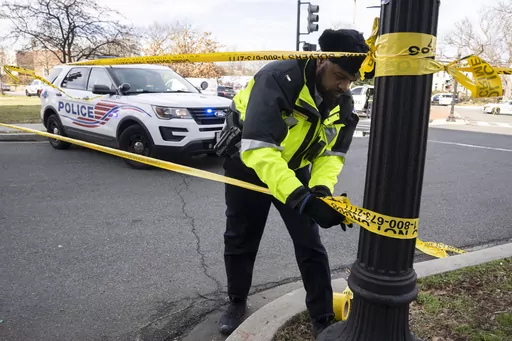 A Washington Metropolitan Police officer, puts yellow tape around the Potomac Avenue Metro Station in Southeast Washington, Feb. 1, 2023. District of Columbia Mayor Muriel Bowser's government has been struggling to handle steadily rising violent crime rates in recent years. Although police and city officials point out that overall crime rates have stayed steady, murders and carjackings have spiked — stoking public anxiety. (AP Photo/Manuel Balce Ceneta, File)