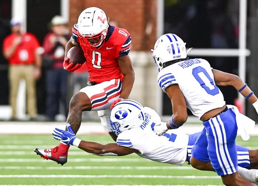 Liberty running back Dae Dae Hunter, left, protects the ball from BYU's Micah Harper during an NCAA college football game Saturday, Oct. 22, 2022, in Lynchburg, Va. (Paige Dingler/The News & Advance via AP)
