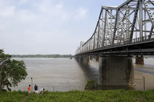 People stand at the base of the Interstate 55 bridge crossing the Mississippi River on May 8, 2011, in Memphis, Tenn. Officials announced Friday, July 12, 2024, that the U.S. Department of Transportation is providing nearly $400 million to replace the 75-year-old bridge. (AP Photo/Jeff Roberson, File)