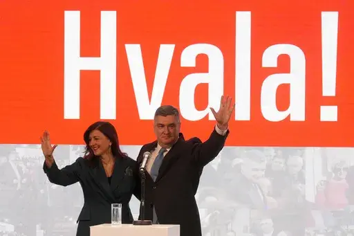 President incumbent Zoran Milanovic with his wife Sanja Music Milanovic greets his supporters as the preliminary results grant him victory in a runoff vote for the Croatian presidential election in Zagreb, Croatia, Sunday, Jan. 12, 2025. The sign reads "Thank You". (AP Photo/Darko Bandic)