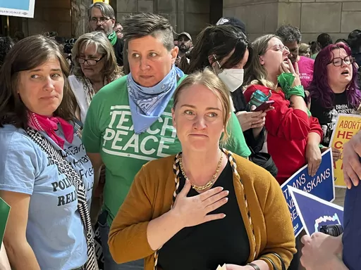 Nebraska state Sen. Megan Hunt, center, stands among supporters minutes after a vote in which the Nebraska Legislature passed a bill to ban abortion at 12 weeks and ban gender-affirming care in minors, Friday, May 19, 2023 in Lincoln, Neb. Hunt said her office has been contacted by families who have reported some pharmacists wrongly refusing to fill prescriptions for gender-affirming medications for their transgender children. (AP Photo/Margery Beck, File)