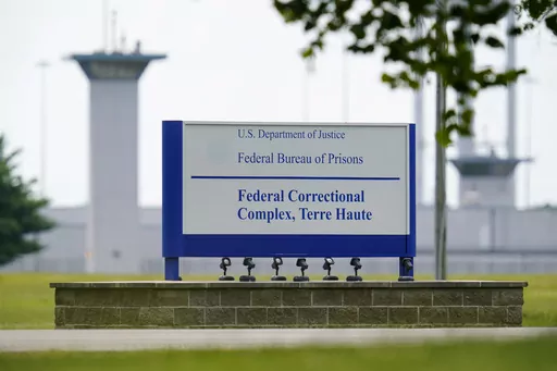 A sign is displayed at the federal prison complex in Terre Haute, Ind., on Aug. 28, 2020. A judge tossed 49-year-old Bruce Webster's death sentence in accordance with a 2002 Supreme Court decision that executing anyone with an intellectual disability violated Eight Amendment protections against “cruel and unusual” punishment. But Justice Department still hasn’t authorized his transfer to a less restrictive unit. (AP Photo/Michael Conroy, File)
