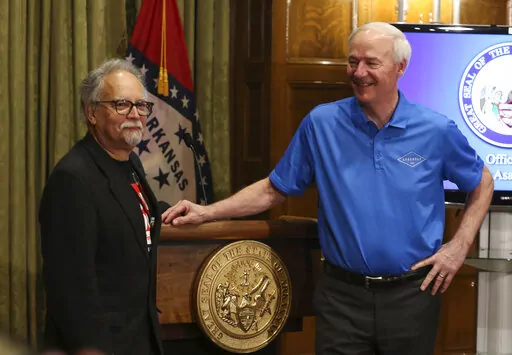 Arkansas Gov. Asa Hutchinson, right,talks with Arkansas Secretary of Health Dr. Jose Romero after a press conference on Tuesday, April 5, 2022, at the state Capitol in Little Rock, Ark. Romero, who has led the state's response to COVID-19 for most of the coronavirus pandemic, announced Tuesday that he is resigning to take a job with the Centers for Disease Control and Prevention.  (Tommy Metthe/The Arkansas Democrat-Gazette via AP)
