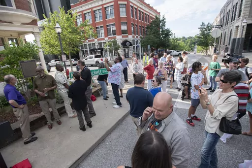 People gather during a dedication ceremony on the Fayetteville square renaming Archibald Yell Boulevard to Nelson Hackett Boulevard on Friday, June 16, 2023 in Fayetteville, Ark. Hackett was the first and last slave to be extradited from Canada back to the United States. A marker telling his story was installed Friday in the flower bed at the northwest corner of the downtown square, in front of the Bank of Fayetteville, the Northwest Arkansas Democrat-Gazette reported. (J.T. Wampler/The Northwes