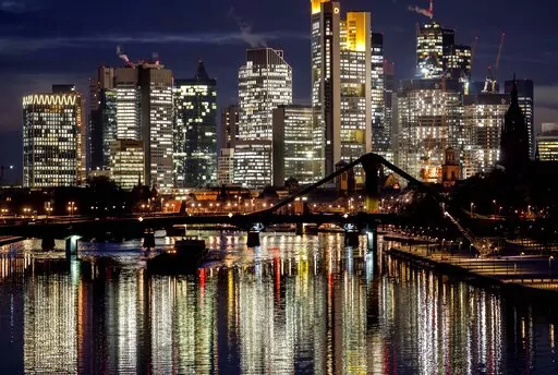 A cargo ship passes the buildings of the banking district in Frankfurt, Germany, Dec. 14, 2022. Europe’s economy has scraped out meager gains at the end of last year as galloping inflation fed by high energy prices and Russia’s invasion of Ukraine deterred people from spending in shops and restaurants. The European Union statistics agency Eurostat reported Tuesday Jan. 31, 2023, that economic output crept 0.1% higher in the last three months of 2022. (AP Photo/Michael Probst, File)
