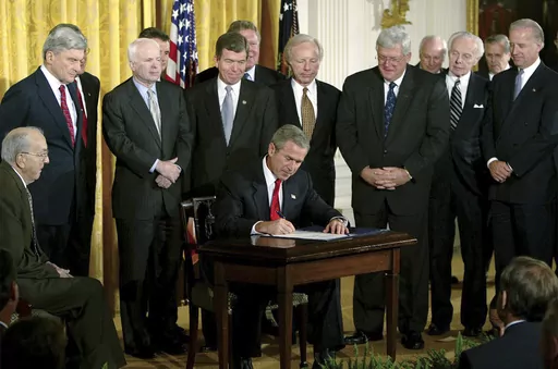 President George W. Bush signs a resolution authorizing the use of force against Iraq, Oct. 16, 2002, in the East Room of the White House. Left to right, Sen. Jesse Helms, R-N.C., Sen. John Warner, R-Va., Sen. John McCain, R-Ariz., Rep. Roy Blunt, R-Mo., Sen. Joseph Lieberman, D-Conn., Speaker the House Dennis Hastert, R-Ill., Rep. Tom Lantos, D-Calif., Sen. Joseph Biden, D-Del. (AP Photo/Ron Edmonds, File)