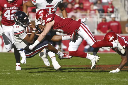 Liberty quarterback Johnathan Bennett (11) is tackled by Arkansas linebacker Bumper Pool, right, during the first half of an NCAA college football game Saturday, Nov. 5, 2022, in Fayetteville, Ark. (AP Photo/Michael Woods)