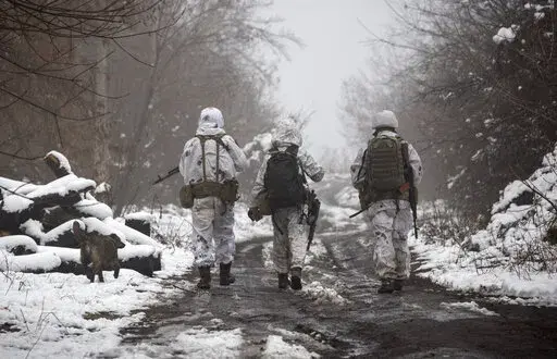 Ukrainian soldiers walks at the line of separation from pro-Russian rebels near Katerinivka, Donetsk region, Ukraine, Tuesday, Dec 7, 2021. Germany's refusal to join other NATO members in supplying Ukraine with weapons has frustrated allies and prompted some to question Berlin's resolve in standing up to Russia. (AP Photo/Andriy Dubchak)