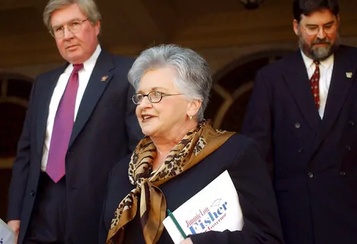 Pulaski County Prosecutor Larry Jegley, left, and Faulkner County Prosecutor H.G. Foster, right, leave the Pulaski County Court House in Little Rock, Ark., with Democratic candidate for Arkansas governor Jimmie Lou Fisher on, Sept. 24, 2002. Fisher, who served as Arkansas' state treasurer for more than two decades and was the Democratic nominee for governor in 2002, died Monday, July 11, 2022, at Arkansas Methodist Medical Center in Paragould, Ark., Mitchell Funeral Home said. She was 80. A caus