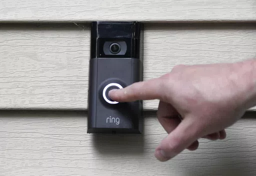 A person pushes the doorbell on his Ring doorbell camera, July 16, 2019, at his home in Wolcott, Conn. The Federal Trade Commission is sending $5.6 million in refunds to consumers as part of a settlement with Amazon-owned Ring, which was charged with failing to protect private video footage from outside access. (AP Photo/Jessica Hill, File)