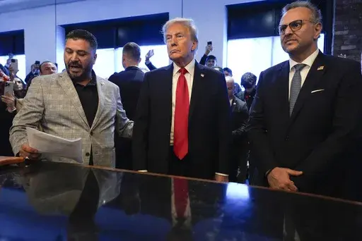 Republican presidential nominee former President Donald Trump, center, listens to Albert Abbas, owner of The Great Commoner, left, as Massad Boulos looks on during a visit to the cafe, Nov. 1, 2024, in Dearborn, Mich. (AP Photo/Julia Demaree Nikhinson, File)