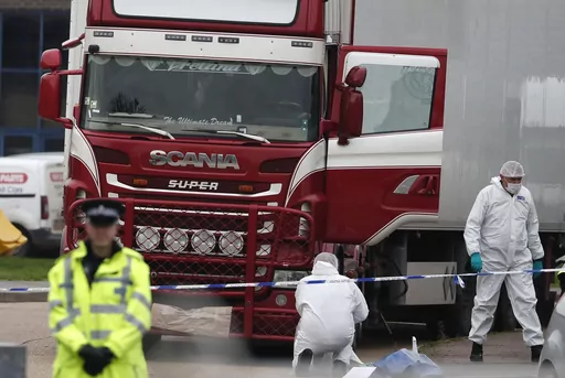 Forensic police officers attend the scene after a truck was found to contain a large number of dead bodies, in Grays, England, Oct. 23, 2019. A Romanian man who was part of an international human smuggling ring was sentenced Tuesday July 11, 2023, to more than 12 years in prison for the deaths of 39 migrants from Vietnam who suffocated were found lifeless in a truck trailer in England in 2019. Marius Mihai Draghici, 50, pleaded guilty last month to 39 counts of manslaughter and conspiracy to ass