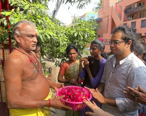 Arjun Viswanathan places his hands on a basket of flowers to be offered to the Hindu deity Ganesh at the Sri Lakshmi Visa Ganapathy Temple on Nov. 28, 2022, in Chennai, a city on the southern coast of India. These "visa temples" can be found in almost any Indian city with a U.S. consulate. They have surged in popularity because of a belief popularized on social media that those who pray there will not just get their visa, but will enjoy a smooth, stress-free path to getting it. (AP Photo/Deepa B