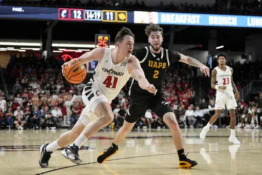Cincinnati guard Simas Lukosius (41) drives against Arkansas-Pine Bluff's Zach Reinhart (2) during the first half of an NCAA college basketball game, Monday, Nov. 4, 2024, in Cincinnati. (AP Photo/Jeff Dean)