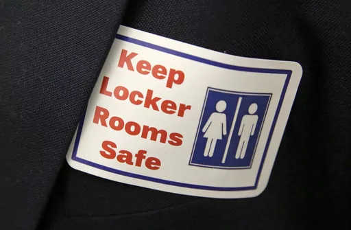 A sticker that reads, "Keep Locker Rooms Safe," is worn by a person supporting a bill that would eliminate Washington's rule allowing transgender people use gender-segregated bathrooms and locker rooms in public buildings consistent with their gender identity, on Jan. 27, 2016, at the Capitol in Olympia, Wash. On Tuesday, March 21, 2023, Arkansas Gov. Sarah Huckabee Sanders signed a law prohibiting transgender people at public schools from using the restroom that matches their gender identity. A