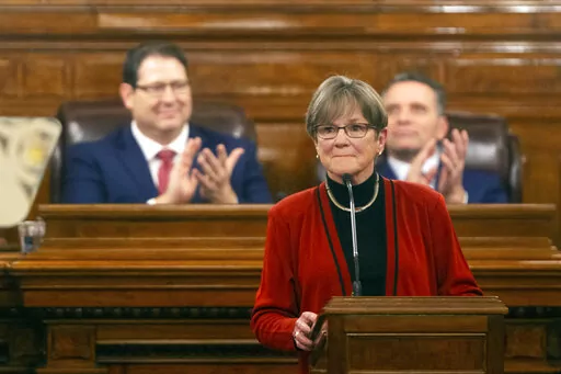 Gov. Laura Kelly is applauded as she begins addressing the Kansas Legislature for the annual State of the State, Tuesday, Jan. 11, 2022, in Topeka, Kan. Democratic and Republican governors are taking vastly different approaches to addressing the ongoing pandemic in their state of the state speeches.   (Evert Nelson/The Topeka Capital-Journal via AP)