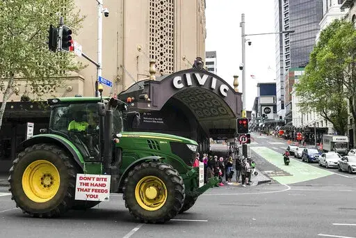 A tractor drives down Queen street in central Auckland during a protest on climate change proposals to make New Zealand farmers pay for greenhouse gas emissions, Thursday, Oct. 20, 2022. New Zealand farmers drove their tractors to towns around New Zealand on Thursday in protest at a proposed new tax on cow burps and other farm greenhouse gas emissions. (Dean Purcell/New Zealand Herald via AP)