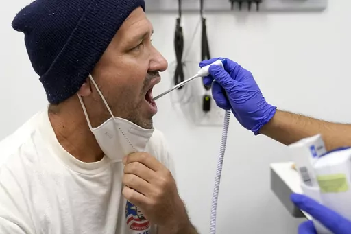 Julio Figuera, 43, has his temperature taken at the Cook County, Ill., medical clinic on Monday, Oct. 16, 2023, in Chicago. "I rarely get sick," he said. "It was the journey that got me sick." Figuera, developed pneumonia since arriving in the U.S. and has been living with hundreds of other asylum seekers at O'Hare International Airport while awaiting more city permanent shelter. When migrants began arriving in Chicago last year, city leaders tapped the county's health system to take over medica