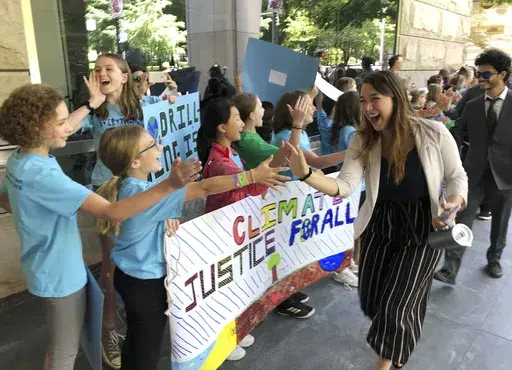 Kelsey Juliana, of Eugene, Ore., a lead plaintiff who is part of a lawsuit by a group of young people who say U.S. energy policies are causing climate change and hurting their future, greets supporters outside a federal courthouse, June 4, 2019, in Portland, Ore. A federal judge ruled on Thursday, June 1, 2023, that a lawsuit brought by young Oregon-based climate activists can proceed to trial years after they first filed the lawsuit in an attempt to hold the nation’s leadership accountable fo