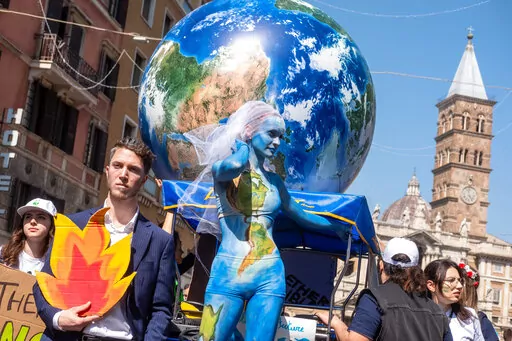 Demonstrators of the Fridays for Future movement march in downtown Rome, Friday, March 25, 2022. Climate activists staged a tenth series of worldwide protests Friday to demand leaders take stronger action against global warming, with some linking their environmental message to calls for an end to the war in Ukraine. (Mauro Scrobogna/LaPresse via AP)
