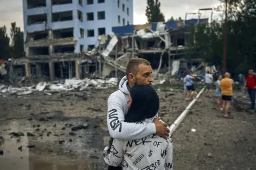 A couple reacts after the Russian shelling in Mykolaiv, Ukraine, Wednesday, Aug. 3, 2022. According local media, supermarket, high-rise buildings and pharmacy were damaged. (AP Photo/Kostiantyn Liberov)