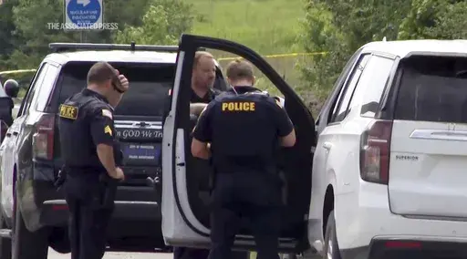 This image from video provided by KATV shows police officers at the scene where Stacy Lee Drake was taken into custody Thursday, June 20, 2024 in Morrilton, Ark. An Alabama man wanted in connection with homicides in Oklahoma and Alabama was apprehended Thursday in Arkansas after a search that spanned multiple southern states, Arkansas State Police said. (KATV via AP)