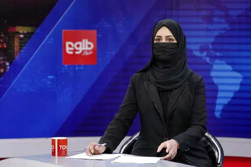 Khatereh Ahmadi a TV anchor wears a face covering as she reads the news on TOLO NEWS, in Kabul, Afghanistan, Sunday, May 22, 2022. Afghanistan's Taliban rulers have begun enforcing an order requiring all female TV news anchors in the country to cover their faces while on-air. The move Sunday is part of a hard-line shift drawing condemnation from rights activists. (AP Photo/Ebrahim Noroozi)